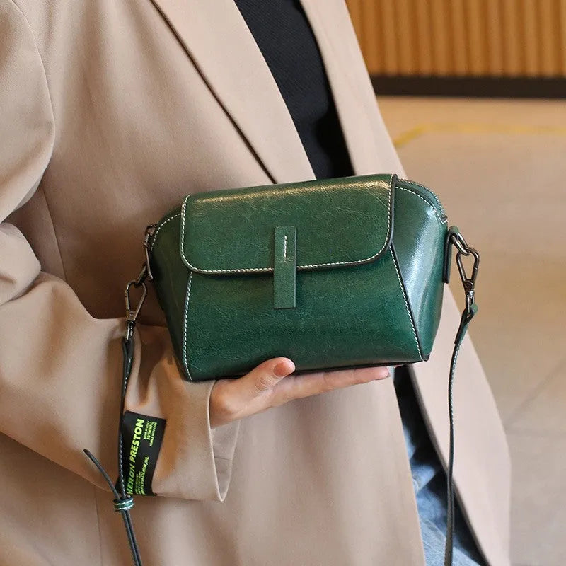Brown women's crossbody messenger bag in soft oil wax leather with shell shape and visible sewing detailing