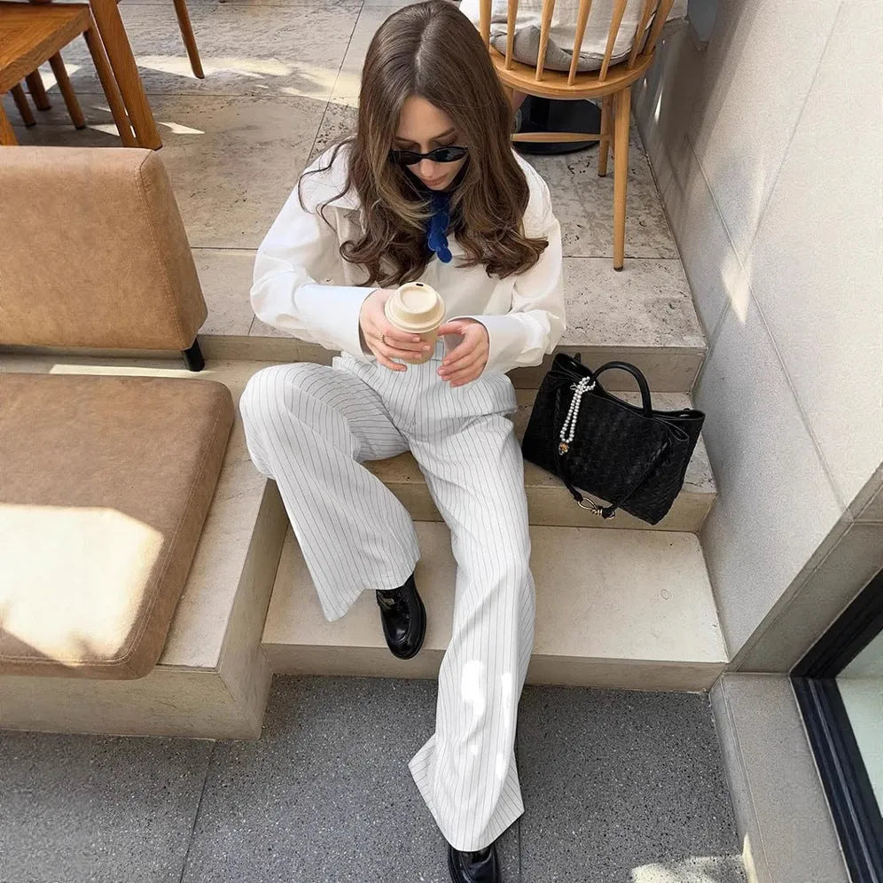 White women's wide-leg trousers with a stripe detail and zip fastening, laid flat.