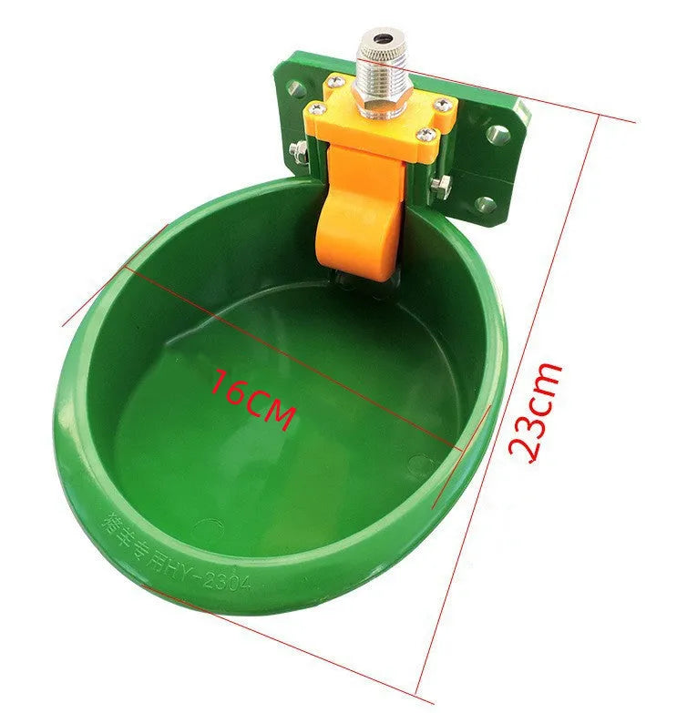 Green plastic automatic water drink bowl for pigs and sheep on a farm.