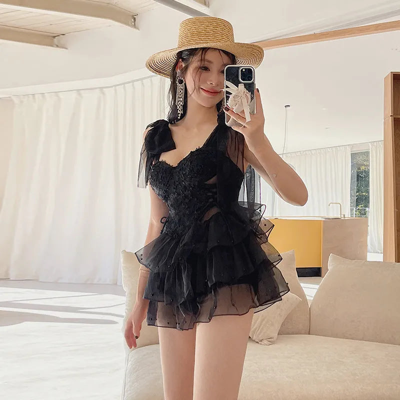 Black conservative one-piece swimsuit with gathered chest detail, sleeveless design