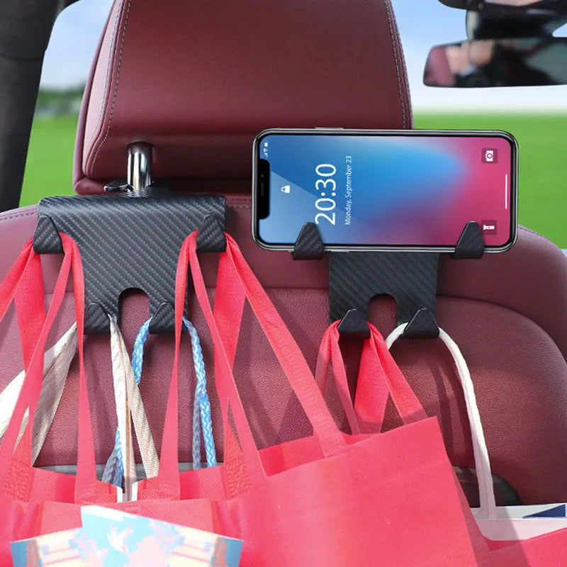 Black ABS car storage hook with carbon fibre pattern, combining a bag hook and mobile phone holder for rear seat installation.