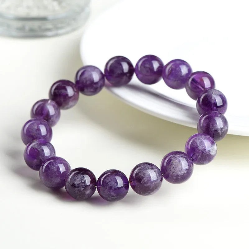 Snow Mountain feather amethyst crystal bracelet with geometric beads and Ruyi elements on a wrist.