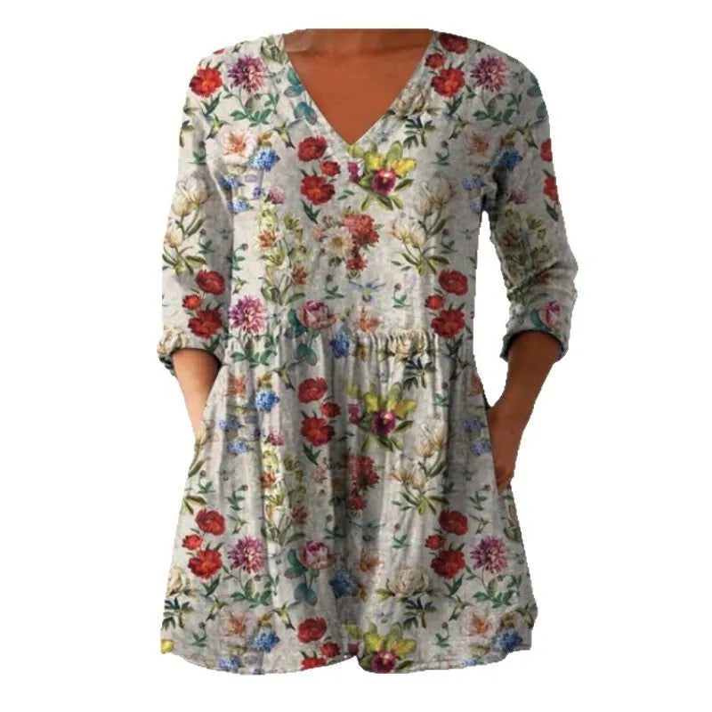 Printed women's loose dress with wide waist and three-quarter length sleeves on a hanger.