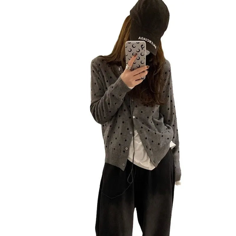 Women's grey knitted cardigan with long sleeves and white crocheted flower details on the front.