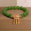 Green jasper bracelet for women with a four-leaf clover dream catcher crystal pendant on a chain.