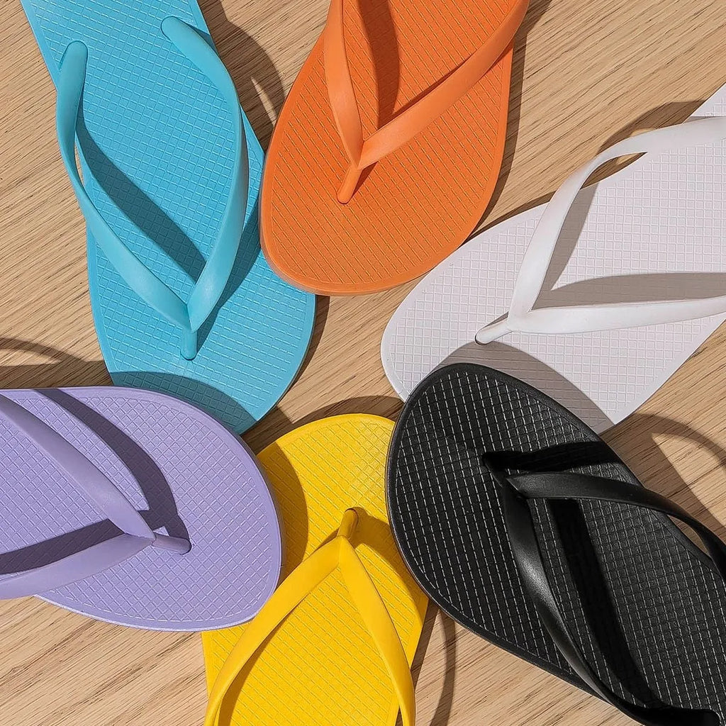 Foldable non-slip plastic slippers with hollow-out PVC sole in orange, purple, black and white.