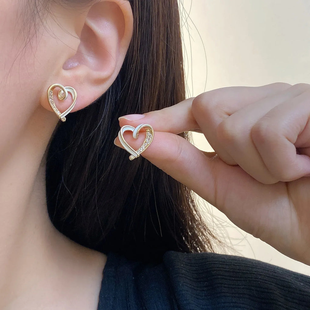 Fashion micro-set zircon asymmetric earrings in copper heart shape with love motif, available in red or white as ear clips or studs