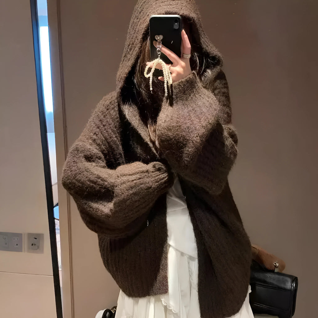 Woman wearing a dark gray retro-style hooded cardigan sweater with a loose fit.