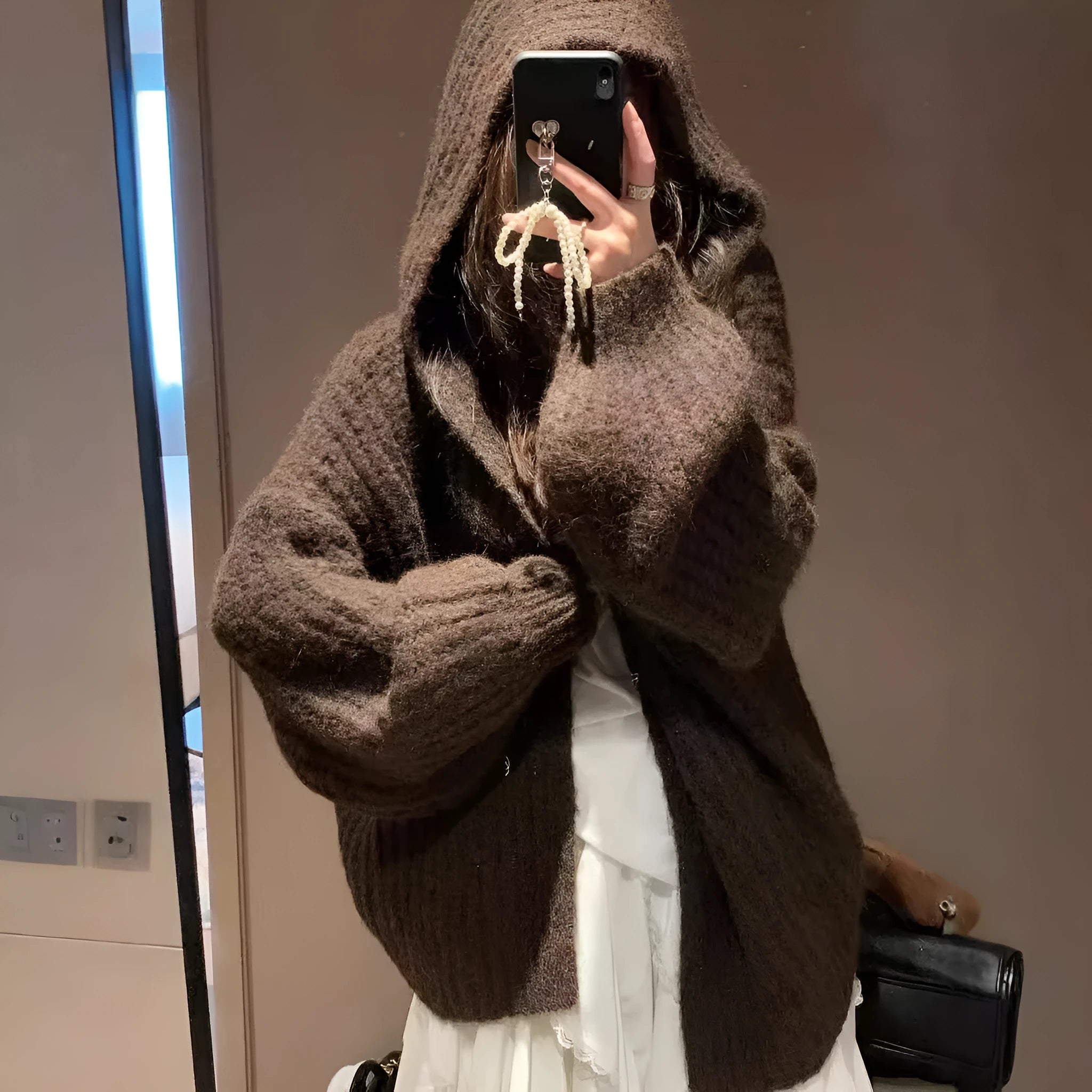 Woman wearing a dark gray retro-style hooded cardigan sweater with a loose fit.