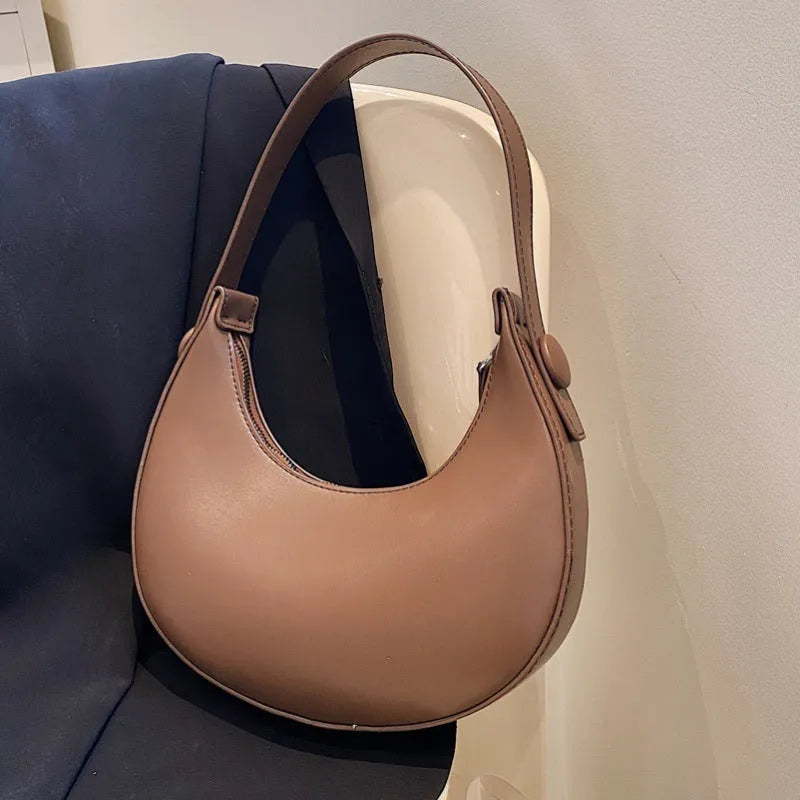 Women's retro dumpling-shaped shoulder bag in PU leather, shown in black, featuring an outer sandwich pocket.