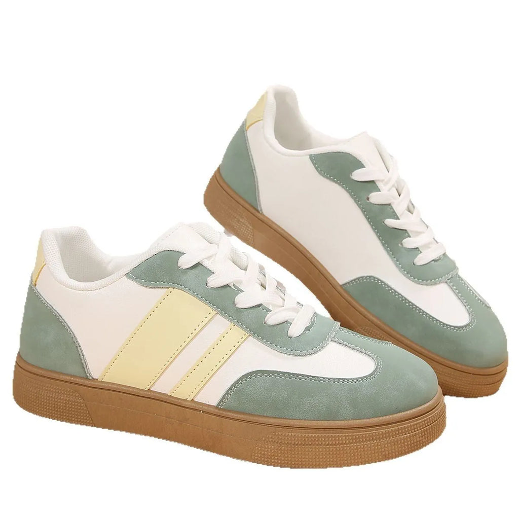 Green women's low-top retro sneakers with white cross straps and stitching on a PU upper.