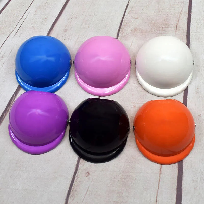 A small dog wearing a solid-colour plastic motorcycle cap helmet on its head.