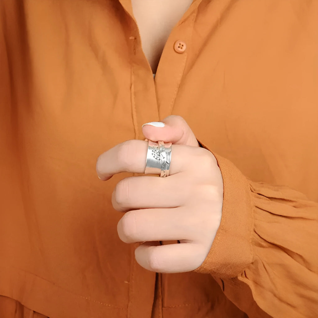 Rotatable silver-colour flower ring showing adjustable design on finger