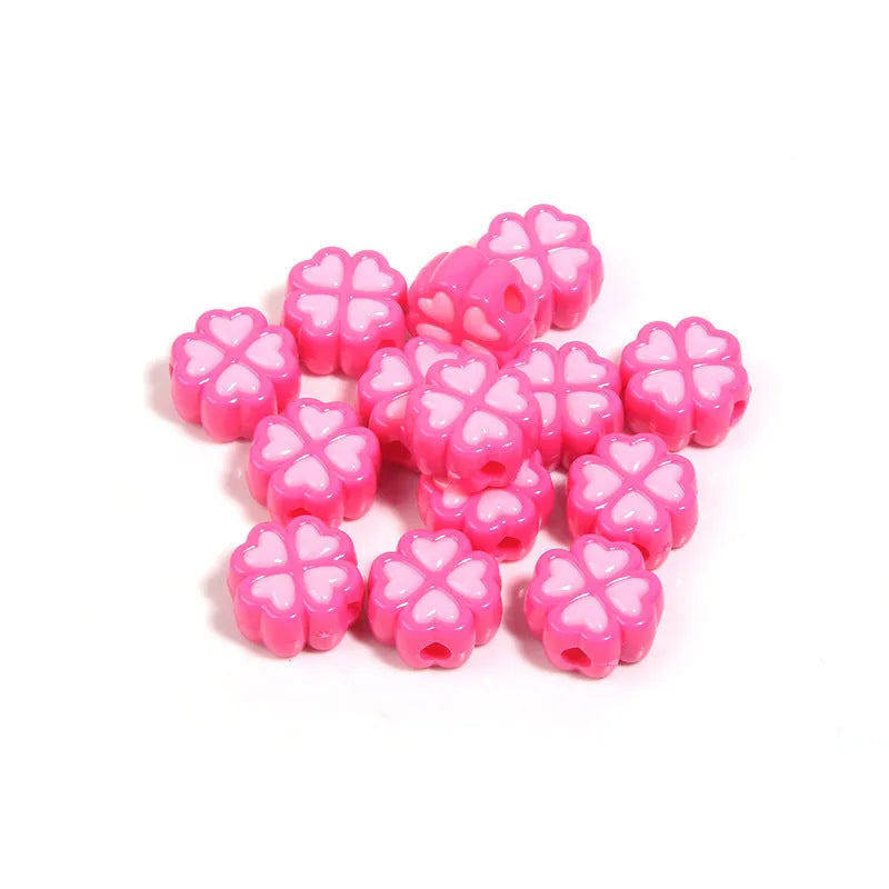 A selection of 15mm frosted acrylic beads in various colours, each showing a four-leaf clover love pattern.