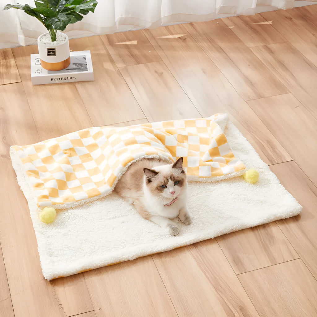 Green plush pet blanket with plaid pattern and fur balls as dog bed mat on sofa