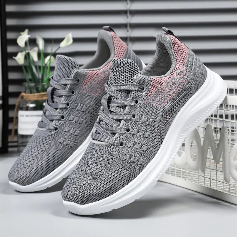 Women's low-top black mesh sneakers with round toe and white PVC sole, featuring front lace-up design.