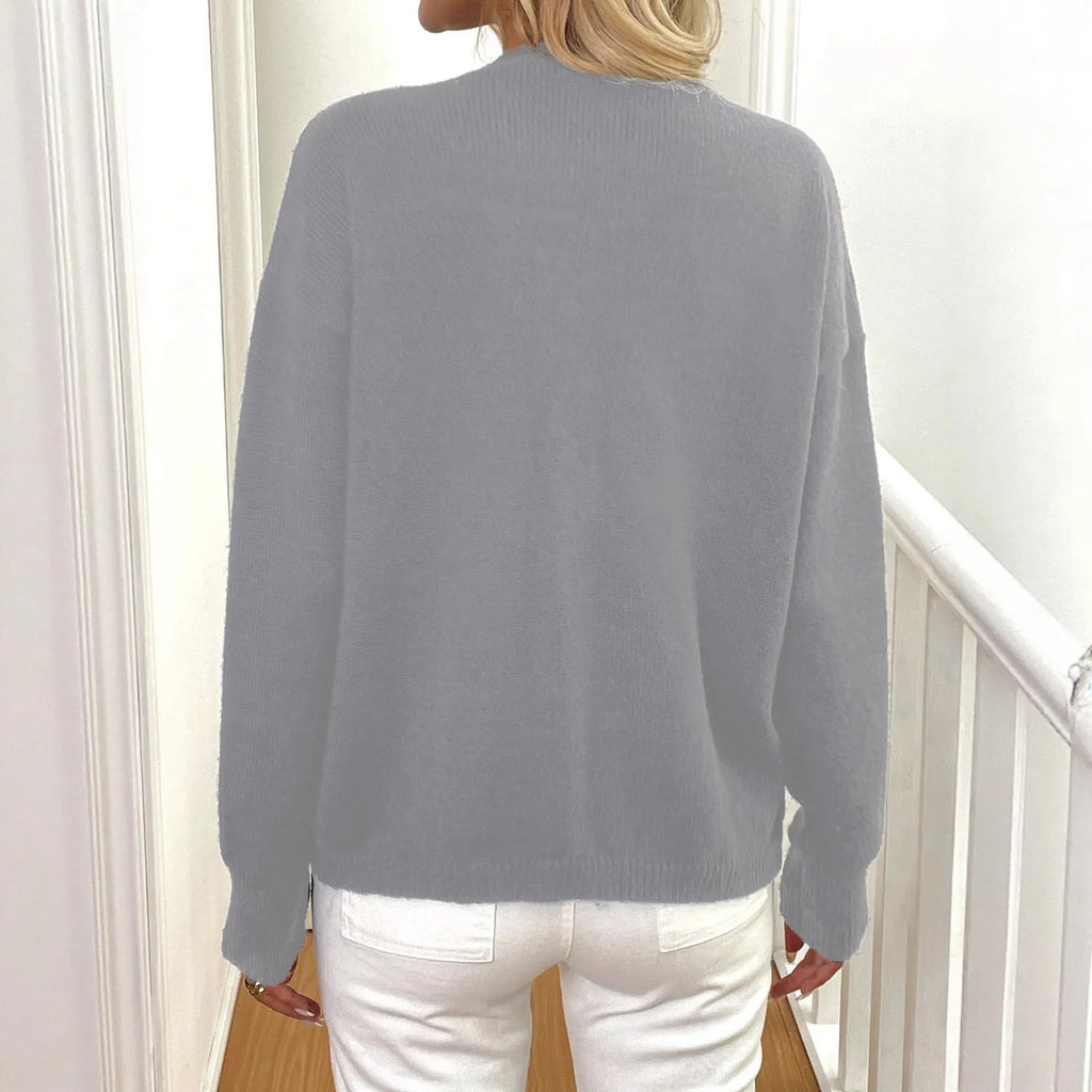A gray women's long sleeve deer plush sweater coat with princess sleeves on a hanger.