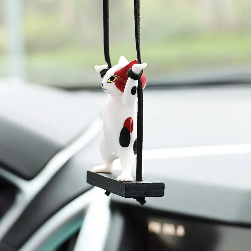 Resin cartoon cat pendant for car interior decoration on a rope, shown in multiple colour options.