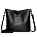 Women's black soft leather bucket-style shoulder bag with minimalist design and visible stitching