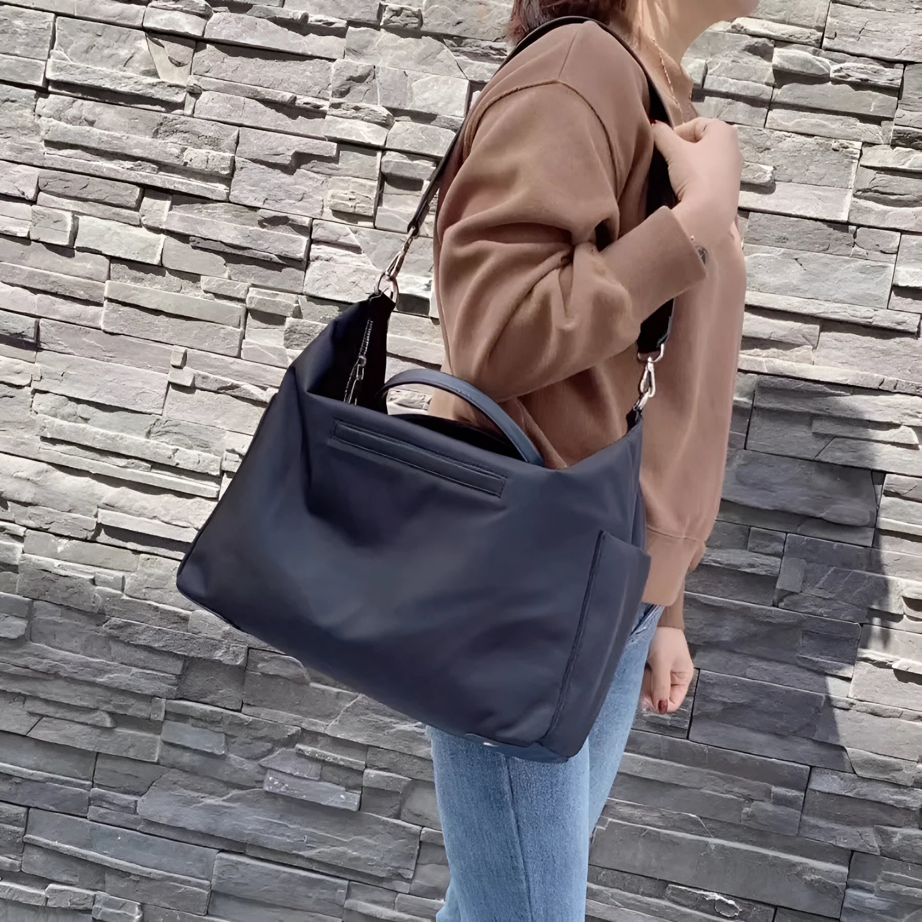 Waterproof nylon shoulder bag with leather accents in black colour showing large capacity interior