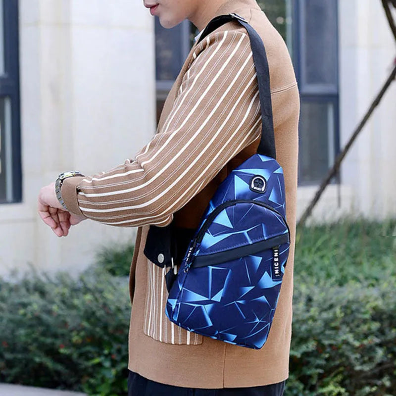 Men's blue print sling chest bag with earphone hole, shown worn crossbody.