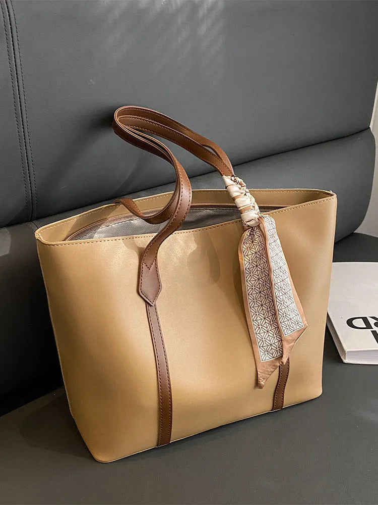 Large soft tote shoulder bag in khaki colour with a crossbody strap and visible sewing line detail.