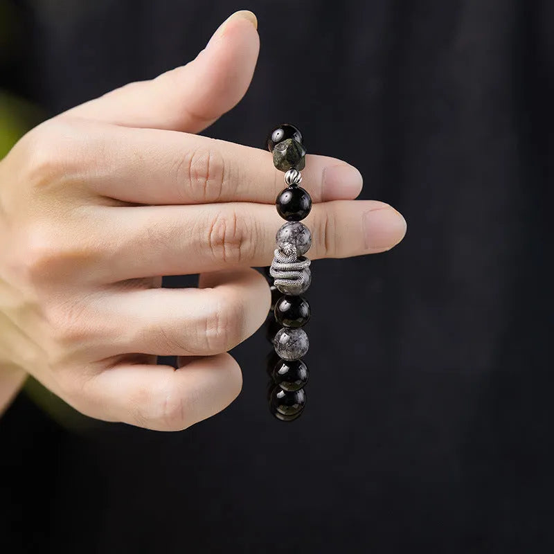 Men's S925 sterling silver bracelet with obsidian black hair crystal and detailed snake zodiac design on a black background.