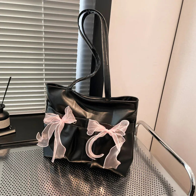 College style black bow tote bag with double shoulder straps showing interior zippered pocket