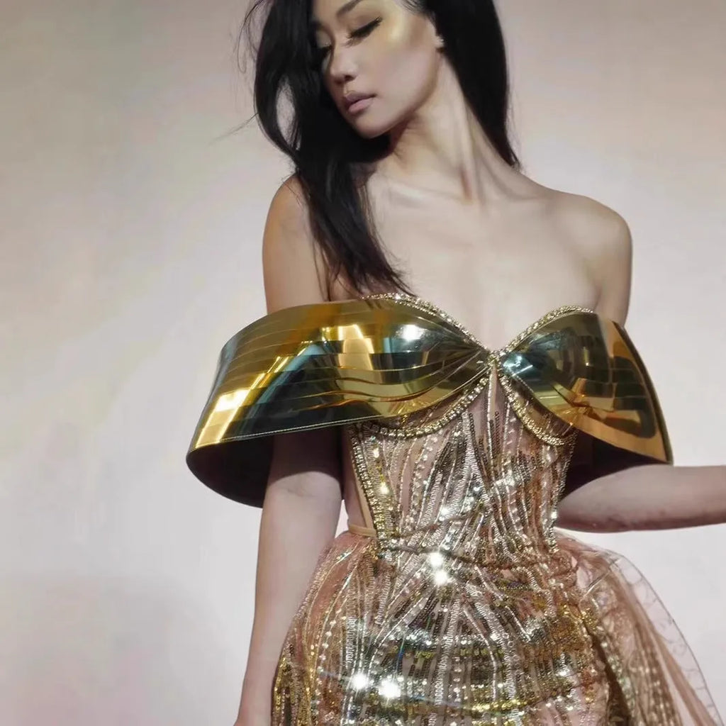 Gold strapless sequin evening dress with high-low hemline and tulle skirt detailing.