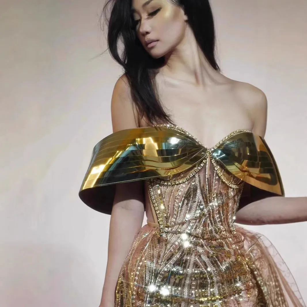 Gold strapless sequin evening dress with high-low hemline and tulle skirt detailing.