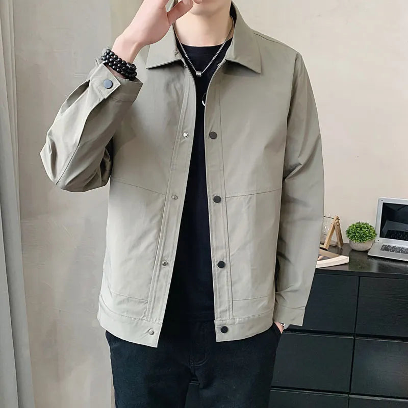 Man wearing a Korean style lightweight single-layer jacket in grey, showing front zip and long sleeves.
