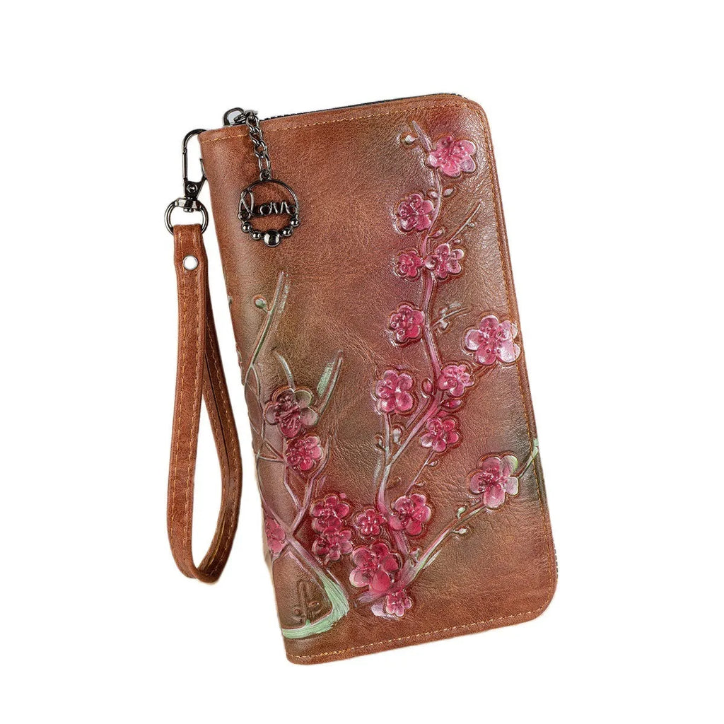 Black embossed floral handbag with hand-painted details and a zipper closure.