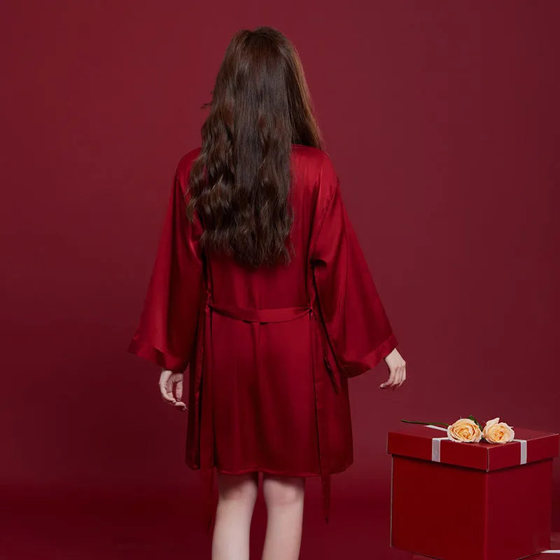 Red long-sleeve ice silk sleepwear set for a man and woman on hangers.