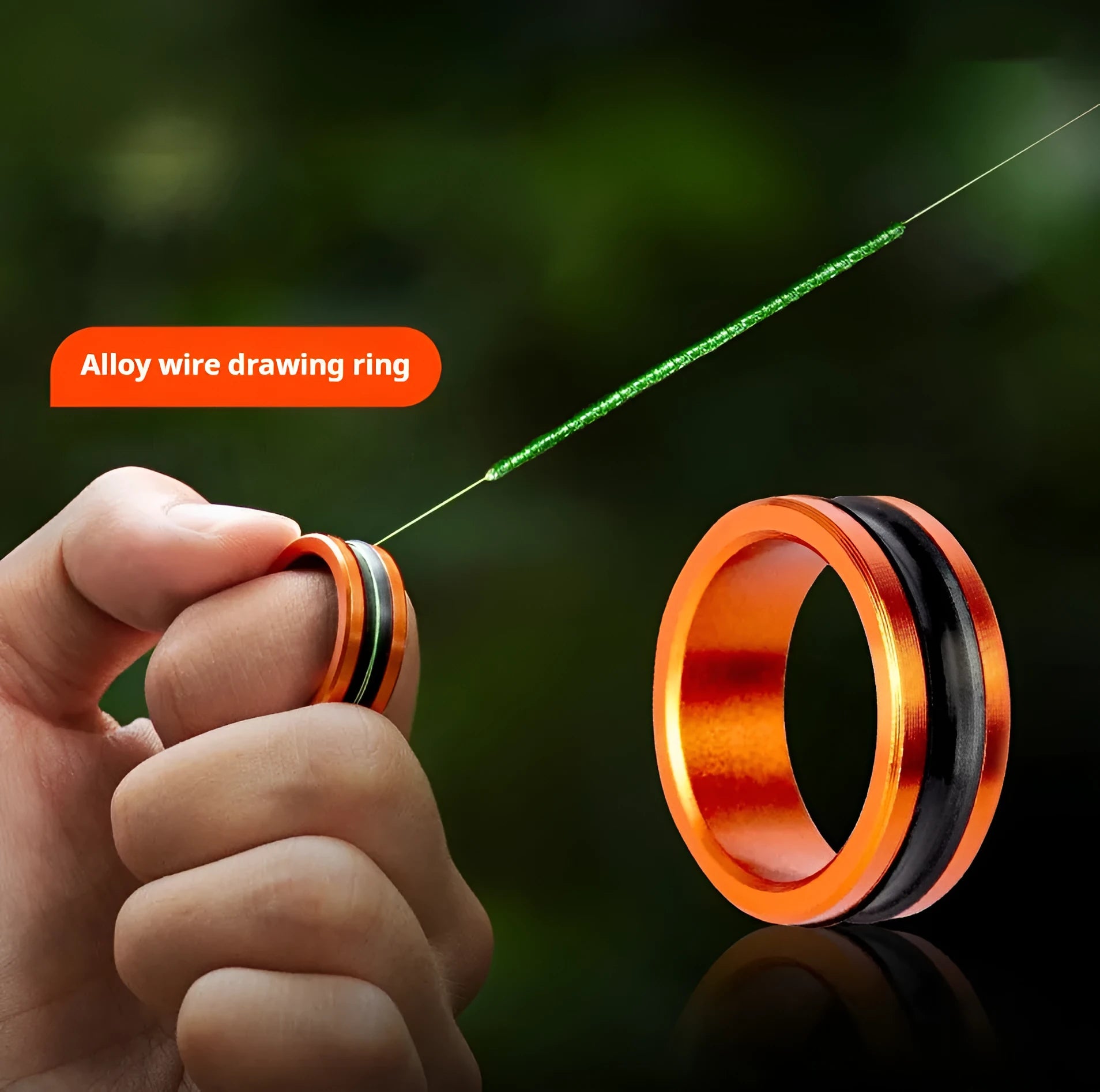 Orange alloy fishing hand guard pull loop tool for hook extraction on a wooden surface.