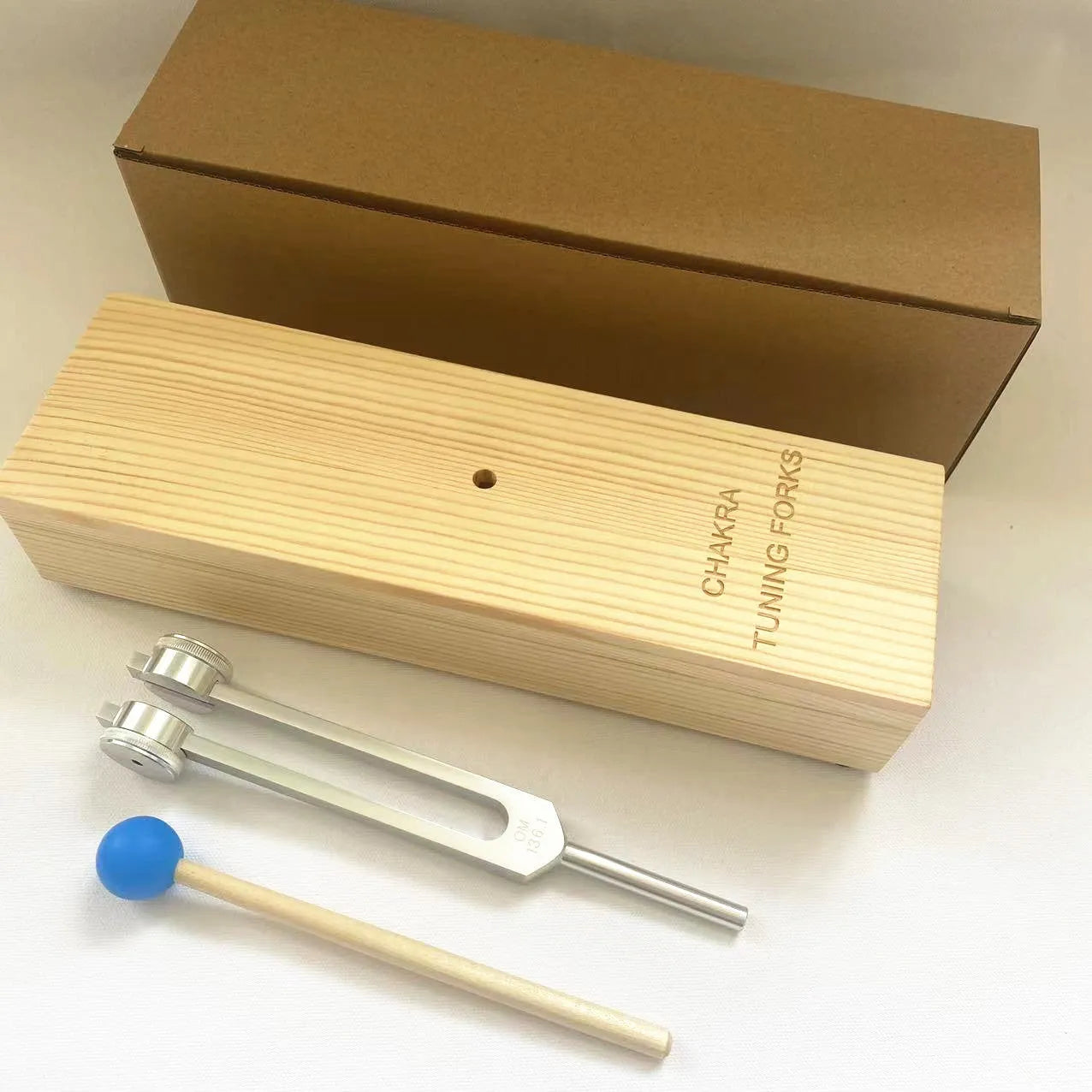 Aluminium alloy 432Hz tuning fork and speaker set on kraft paper box