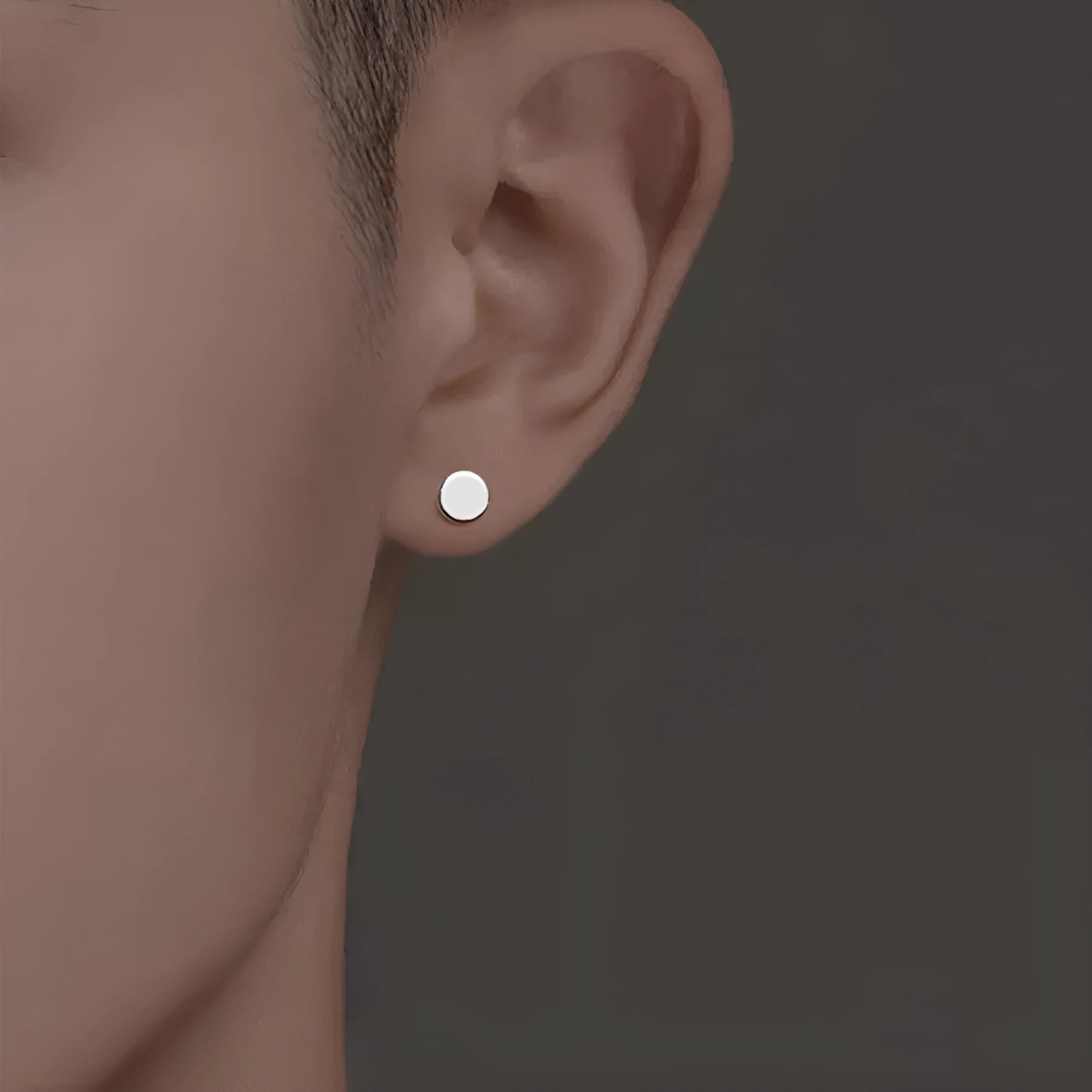 A pair of flat, round S999 sterling silver stud earrings on a plain background.