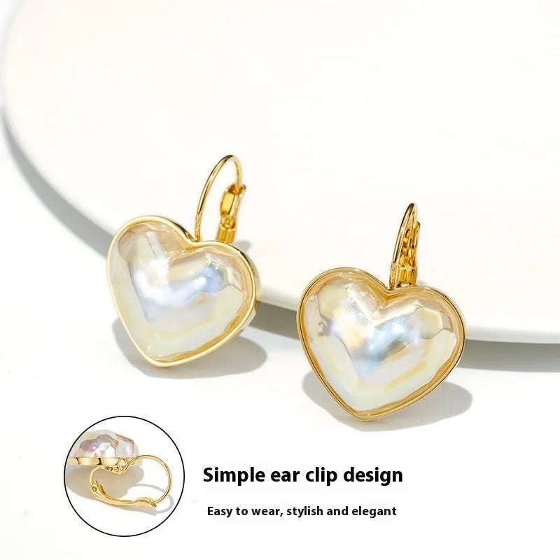 A pair of gold-coloured clip-on earrings with a metallic finish and natural styling.