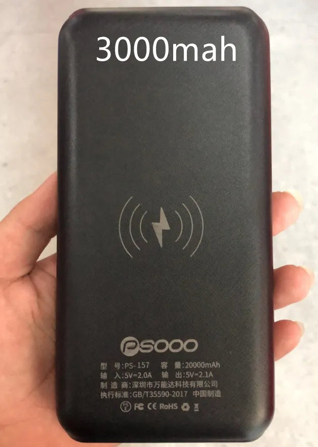 Black portable power bank with wireless charging surface and three USB ports for multiple device charging