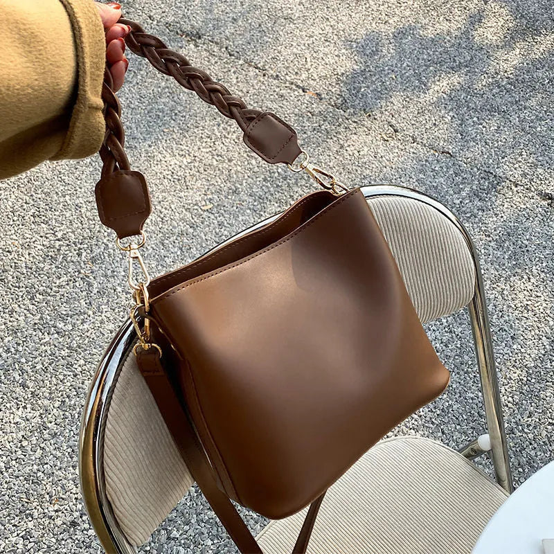 Retro woven PU leather crossbody bucket bag in khaki colour showing adjustable strap and bucket shape