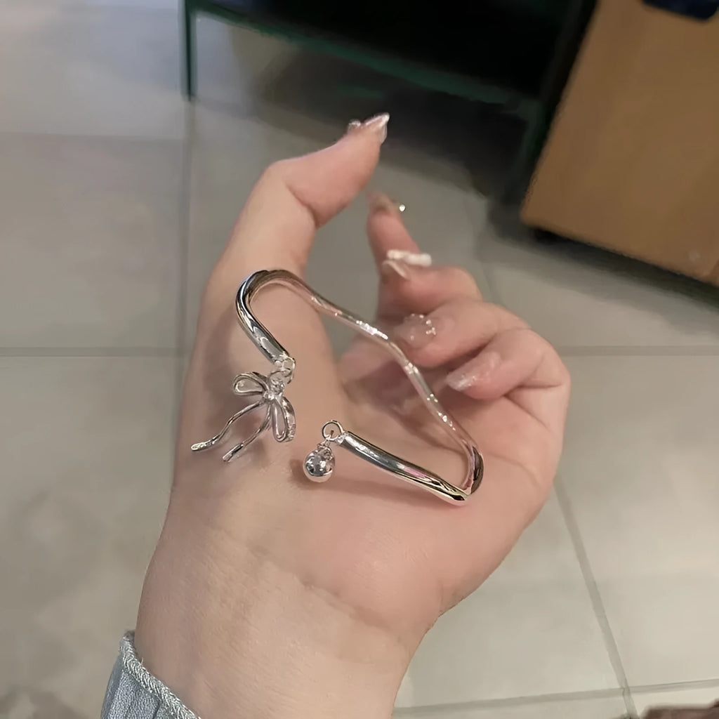 Silver adjustable bow bracelet with bell opening mechanism on zinc alloy chain