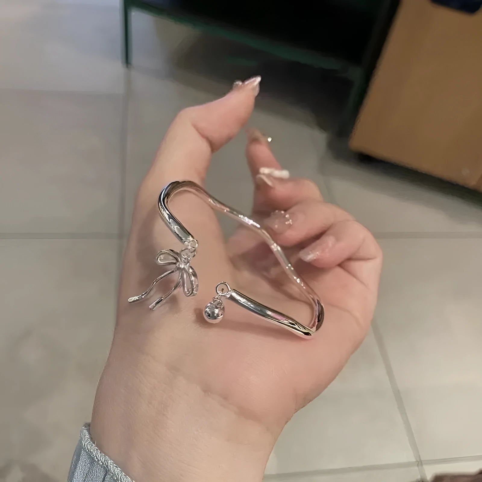 Silver adjustable bow bracelet with bell opening mechanism on zinc alloy chain