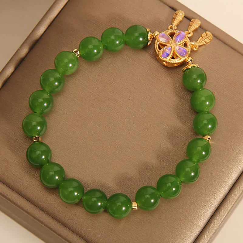 Green jasper bracelet for women with a four-leaf clover dream catcher crystal pendant on a chain.