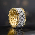 Geometric two-tone copper ring with a round zircon stone, shown on a finger.