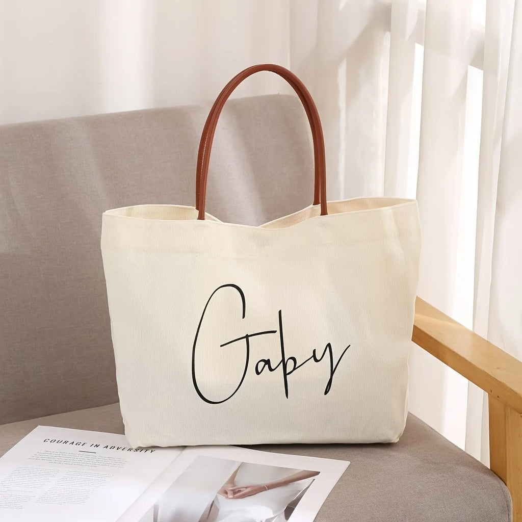 Beige white canvas tote bag with reinforced straps, shown flat and empty.