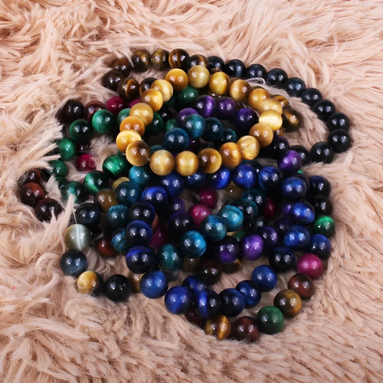 Natural tiger's eye crystal bead bracelet with round beads on a wrist, showing colour variations.