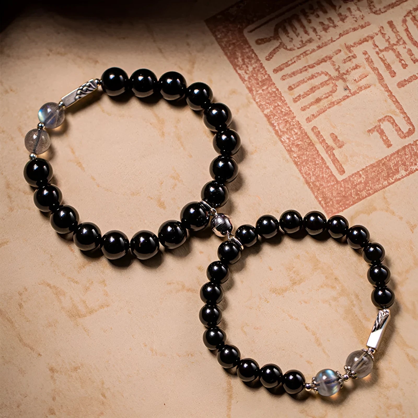 Obsidian couple bracelet DIY kit with 8mm and 10mm black beads and cord for assembly.