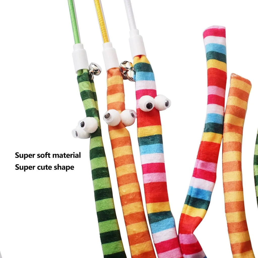 A colourful cat teaser wand with a long plush strip and a bell, held by a person.