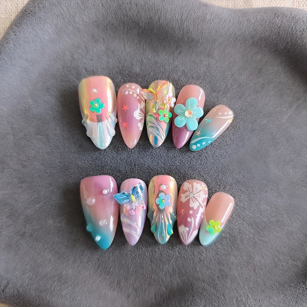 Handmade three-dimensional flower and butterfly nail art sculptures in assorted sizes on a manicure set.