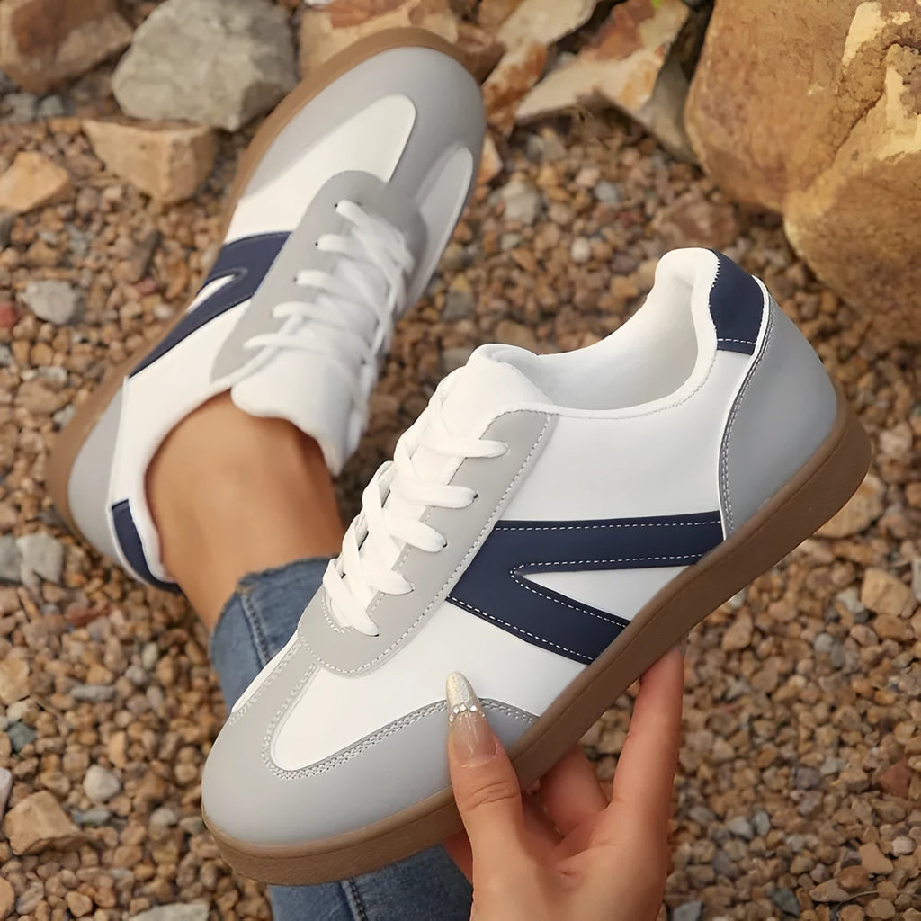 Blue women's low-top flat training shoes with lace-up front and rubber sole.