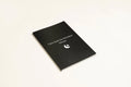 Black hardcover dream journal notebook with minimalist design on a desk.